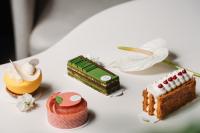 成都BuYuan Hotel - Near Wuhou Shrine, Chunxi Road,T aikooli, Tianfu Square, People's Park, Chengdu Museum, Very close to the Sichuan University , Exit C of Huaxiba on Metro Line 1,Provides Welcome refreshments ,Minibar,Laundry & Luggage delivery service的桌子上摆放着一组不同类型的蛋糕