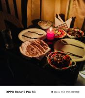 una mesa cubierta con cuencos de comida y una vela en Check Inn Homes, Rishikesh Tapovan, en Rishīkesh