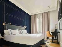 a bedroom with a large bed with a blue wall at Only YOU Boutique Hotel Madrid in Madrid