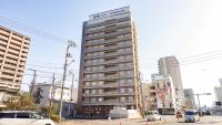 a tall building in the middle of a city at Toyoko Inn Takamatsu Ekimae in Takamatsu