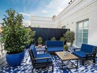 a patio with blue chairs and a table and potted plants at Only YOU Boutique Hotel Madrid in Madrid