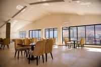 Un comedor con mesas y sillas y ventanas. en Lodges By Baron Hunza Attabad Lake, en Hunza