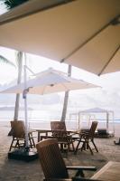 un groupe de chaises et un parasol sur la plage dans l'établissement Station One Beach Resort, à El Nido