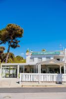 a white building with a tree in front of it at The Garden in Pulsano