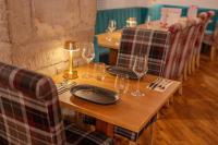 a wooden table with wine glasses and plates on it at The Cornhill Inn in Falkirk