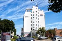 a white building with a sign on the side of it at WIROtel Warnemünde in Warnemünde
