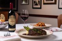 Una mesa con un plato de comida y una copa de vino. en Island Grand at TradeWinds, en St Pete Beach