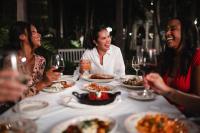 Un grupo de mujeres sentadas alrededor de una mesa comiendo comida en Island Grand at TradeWinds, en St Pete Beach
