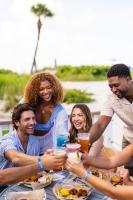 un grupo de personas sentadas alrededor de una mesa con comida en Island Grand at TradeWinds, en St Pete Beach