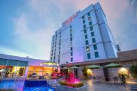 Un hotel con mesas y sillas frente a un edificio. en Ramada Plaza by Wyndham Panama Punta Pacifica, en Panamá