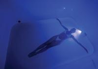 a person swimming in the water with a light at Stay Wellbeing & Lifestyle Resort in Rawai Beach