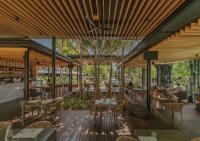 a restaurant with wooden ceilings and tables and chairs at Stay Wellbeing & Lifestyle Resort in Rawai Beach