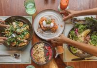 a wooden table with plates of food on it at Stay Wellbeing & Lifestyle Resort in Rawai Beach