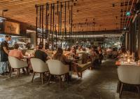 a group of people sitting at tables in a restaurant at Stay Wellbeing & Lifestyle Resort in Rawai Beach