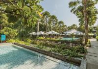 a swimming pool with umbrellas and chairs and a resort at Stay Wellbeing & Lifestyle Resort in Rawai Beach