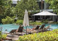 a group of people laying in chairs in a pool at Stay Wellbeing & Lifestyle Resort in Rawai Beach