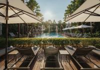 a pool with chairs and umbrellas in front of a pool at Stay Wellbeing & Lifestyle Resort in Rawai Beach