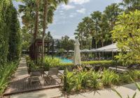 a pool at a resort with chairs and a umbrella at Stay Wellbeing & Lifestyle Resort in Rawai Beach