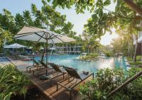 a pool at a resort with chairs and an umbrella at Stay Wellbeing & Lifestyle Resort in Rawai Beach