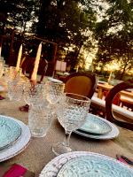 a table with blue and white plates and wine glasses at OAK Glamping Relax in Manziana