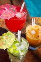 two cocktails with umbrellas on a wooden table at Pousada Arte Urquijo in Paraty