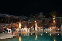 un restaurante junto a una piscina por la noche en Argo Village, en Santorini