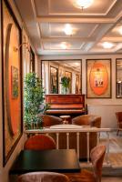 ein Restaurant mit einem Klavier, Tischen und Stühlen in der Unterkunft Logis Hotel Les Glycines in Arles-sur-Tech