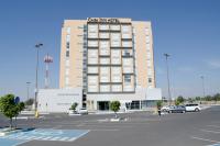 Un edificio con un estacionamiento enfrente. en Casa Inn Galerias Celaya, en Celaya
