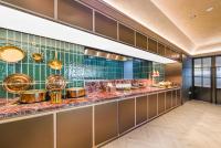 a restaurant with a counter with food at 桔子上海浦东机场川环南路酒店 in Shanghai