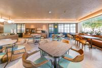 a restaurant with tables and chairs and a kitchen at 桔子上海浦东机场川环南路酒店 in Shanghai