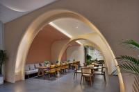 een eetkamer met tafels en stoelen en een boog bij Lijiang Bamboo Elegance Court Hotel in Lijiang