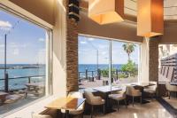 a restaurant with tables and chairs and a view of the ocean at Kensington Resort Jeju Hanlim in Jeju