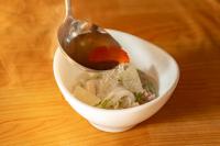 Ein Löffel wird aus einer Schüssel Suppe gehoben. in der Unterkunft Chiangkhan River Green Hill in Ban Noi