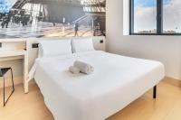 Una cama blanca en una habitación con una foto en la pared en B&amp;B Hotel Milano San Siro, en Milán