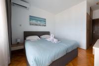 ein Schlafzimmer mit einem Bett mit einem weißen Hund drauf in der Unterkunft Villa Okruk-10 meters away from the beach in Trogir