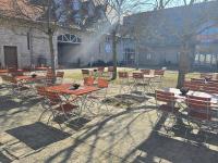 eine Gruppe von Tischen und Stühlen vor einem Gebäude in der Unterkunft Hotel Grenzenlos im Alten Gut in Würzburg