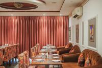 a dining room with a long table and red curtains at Hotel Highway Greens Near VR Punjab Mall Airport Road Mohali Chandigarh in Mohali
