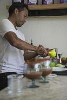 Un hombre parado frente a un mostrador con algunas bebidas. en Tekoa Spaces, en San Antonio Palopó