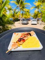 una rebanada de pizza en un plato en una mesa en Pousada Enero, en Maragogi