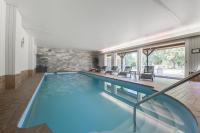 a large swimming pool with blue water in a building at Parc Hôtel in Wangenbourg