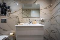 ein weißes Badezimmer mit Waschbecken und Spiegel in der Unterkunft Valencia Apartment - By Harim in Eilat