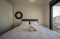 Schlafzimmer mit einem großen weißen Bett und einem Spiegel in der Unterkunft Valencia Apartment - By Harim in Eilat