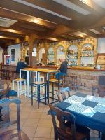 ein Restaurant mit einer Bar mit Tischen in der Unterkunft Hostal Restaurante Bar Conrad in Abades
