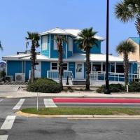 een blauw huis met palmbomen voor een straat bij Double Take! Renovated Vacation Home in Panama City Beach