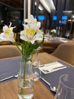 een vaas gevuld met witte bloemen op een tafel bij Zenith Canyonscape in Praia Grande