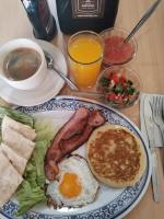 een bord ontbijtproducten met eieren, spek en toast bij Aroma Hotel in Puebla