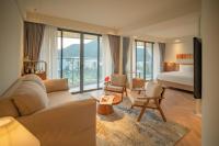 クイニョンにあるA&#39;dor Hotel &amp; Spa Quy Nhơnのベッドとソファと椅子があるホテルの部屋