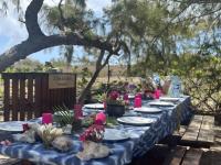 uma longa mesa azul com pratos e flores sobre ela em Catamaran Z'ile cruise em Grand Baie