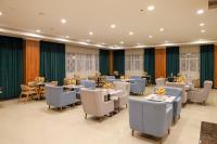 um restaurante com mesas e cadeiras em uma sala em Eliana Hotel em Al Khobar