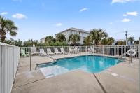 einen Pool mit Stühlen und einem Zaun in der Unterkunft Beautiful Two Bedroom, Two Bathroom First Floor Condo in Gulf Shores! in Gulf Shores
